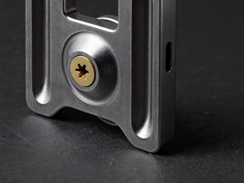 Makroaufnahme einer Schnellwechselplatte aus Aluminium mit Messingschraube auf Schiefer